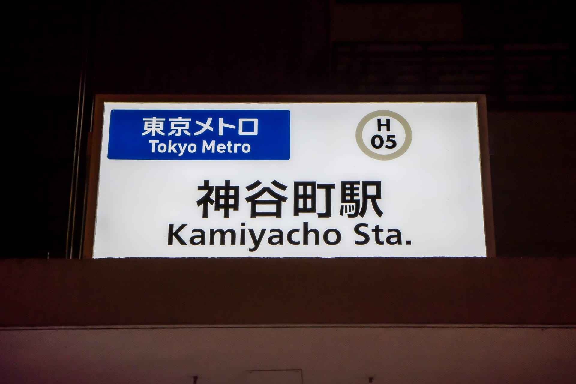 東京メトロの神谷町駅の標識は、駅コード「H 05」と日本語と英語の文字が併記されており、近くの神谷町フランス語教室マンツーマンセッションに参加する通勤者にとって便利なスポットとなっています。.