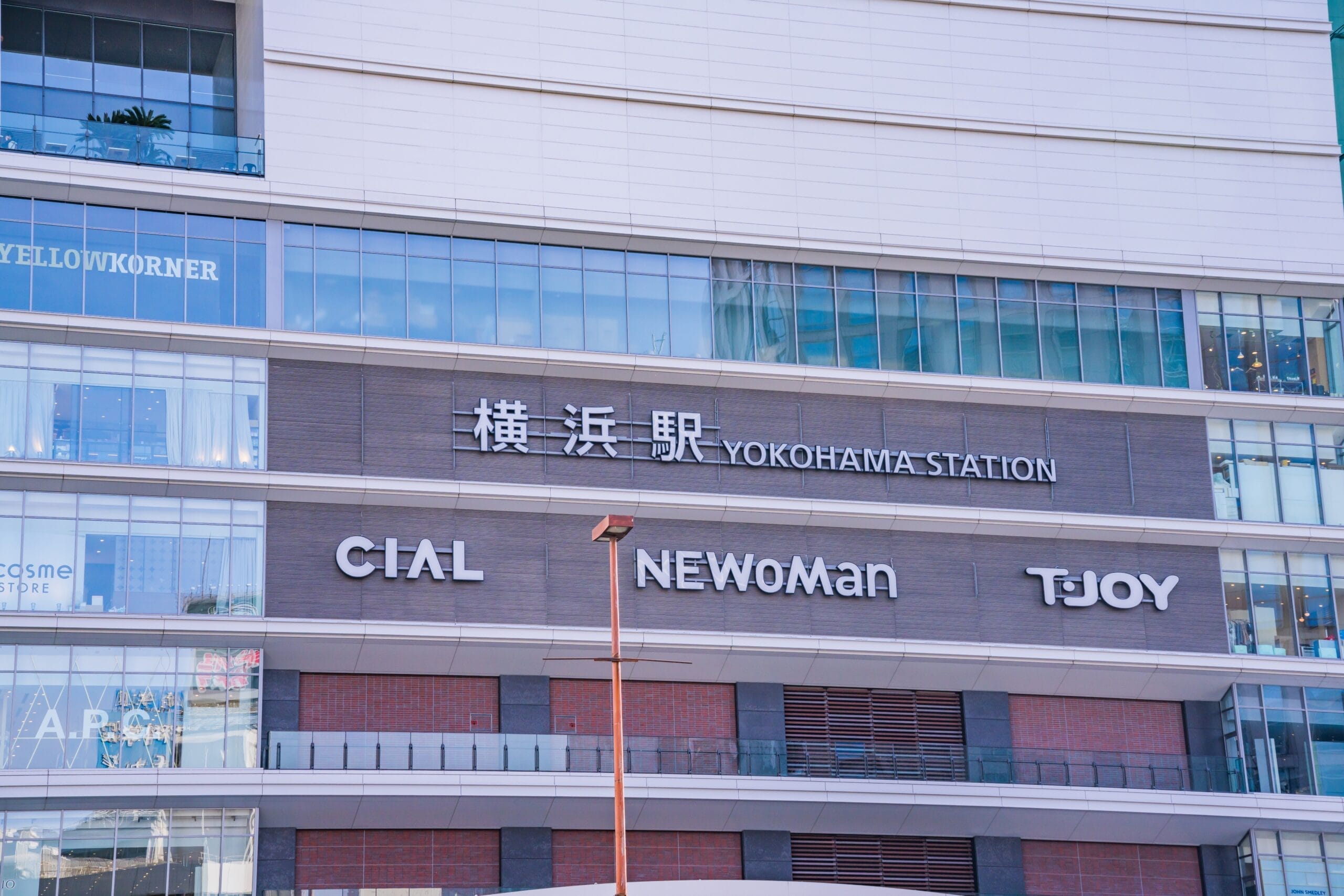 横浜駅の外観には「CIAL」「NEWoMan」「TJOY」などの看板が掲げられています。モダンな建築と大きなガラス窓が特徴のこの賑やかな拠点では、ショッピングからマンツーマンのフランス語教室 (フランス語教室マンツーマン) まで、さまざまなサービスを提供しています。.