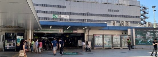 行き交う人で賑わう柏のステーションモールの入り口。高島屋の看板が頂上に飾られたこの建物は、晴れた空の下、タイル張りの前景を見せて立っています。近くのフランス語教室マンツーマンでは、個人に合わせた語学レッスンを提供しています。.