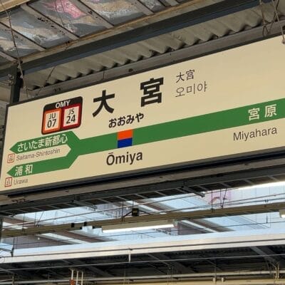 大宮駅の標識には、プラットフォームの詳細やさいたま新都心駅、宮原駅などの隣接駅が表示されており、日本語、英語、韓国語、さらには語学レッスンを求める旅行者のニーズに応えるためにフランス語でも案内されています。.