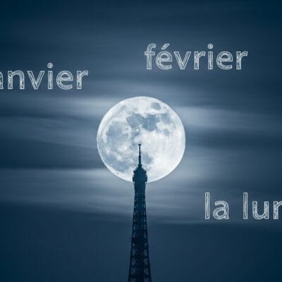 夜のエッフェル塔の背後の満月。白い文字でフランス語の「janvier」、「février」、「la lune」が重ねて表示されています。.